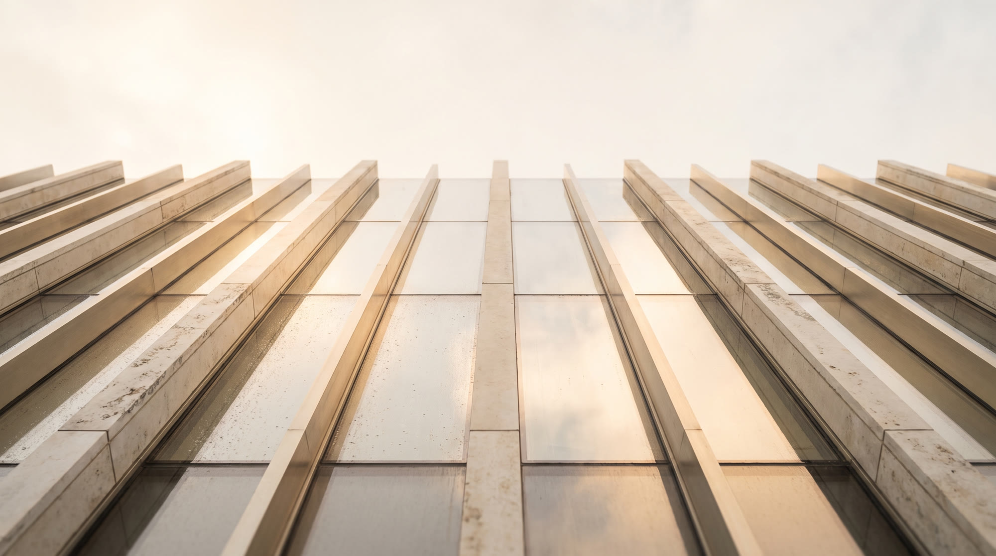 Champagne dawn light raking across a luxury tower glass facade